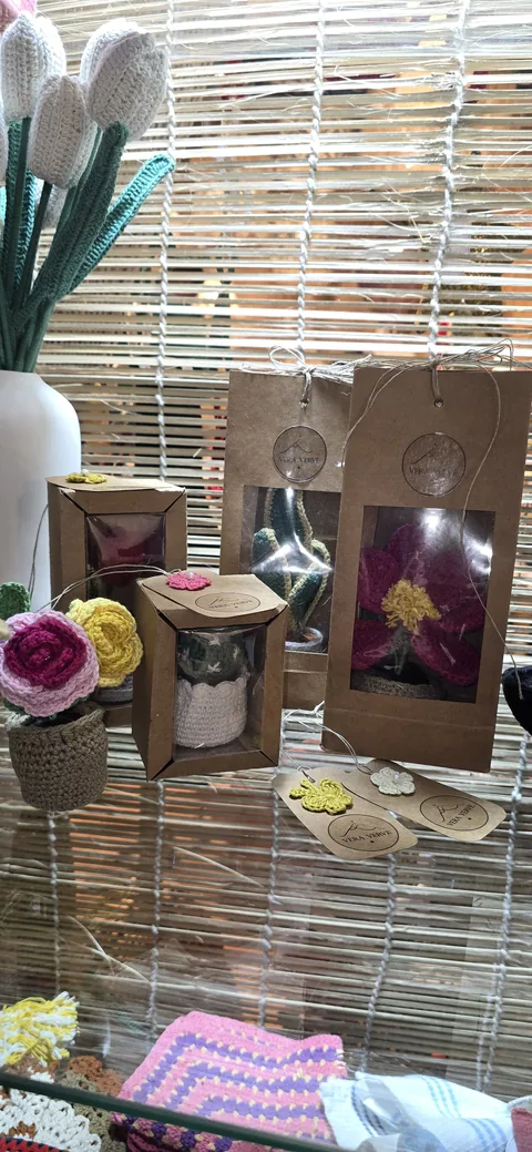 Kraft gift boxes with Vera Verve tags holding crochet flowers, beside crochet tulips and small crochet pieces, at our stall, IHGF Delhi Fair Spring 2026.