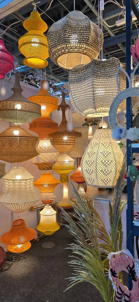 Crochet pendant lamps in yellow, orange, cream and natural yarns lit up inside the Vera Verve stall at IHGF Delhi Fair Autumn 2026.