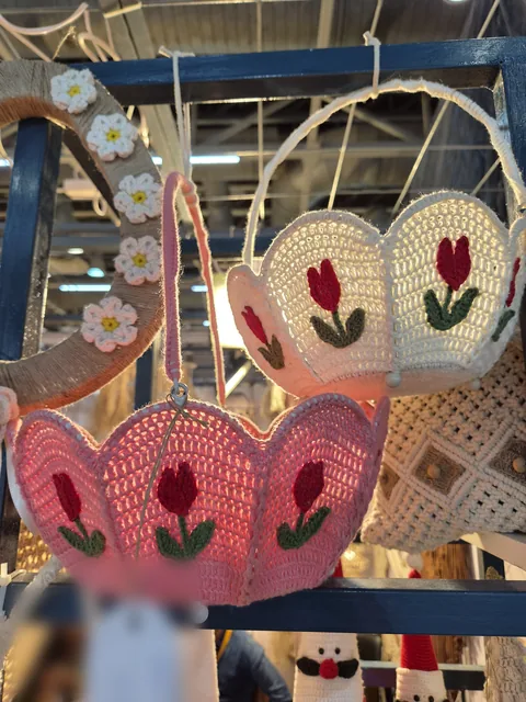 Two crochet baskets with scalloped rims and red tulips, one pink and one cream, hanging at our stall, IHGF Delhi Fair Autumn 2026.