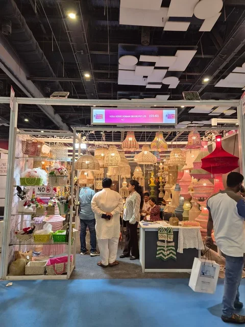 Visitors looking at crochet lamps and baskets inside the Vera Verve stall at Bharatiya Vyapar Mahotsav 2026.
