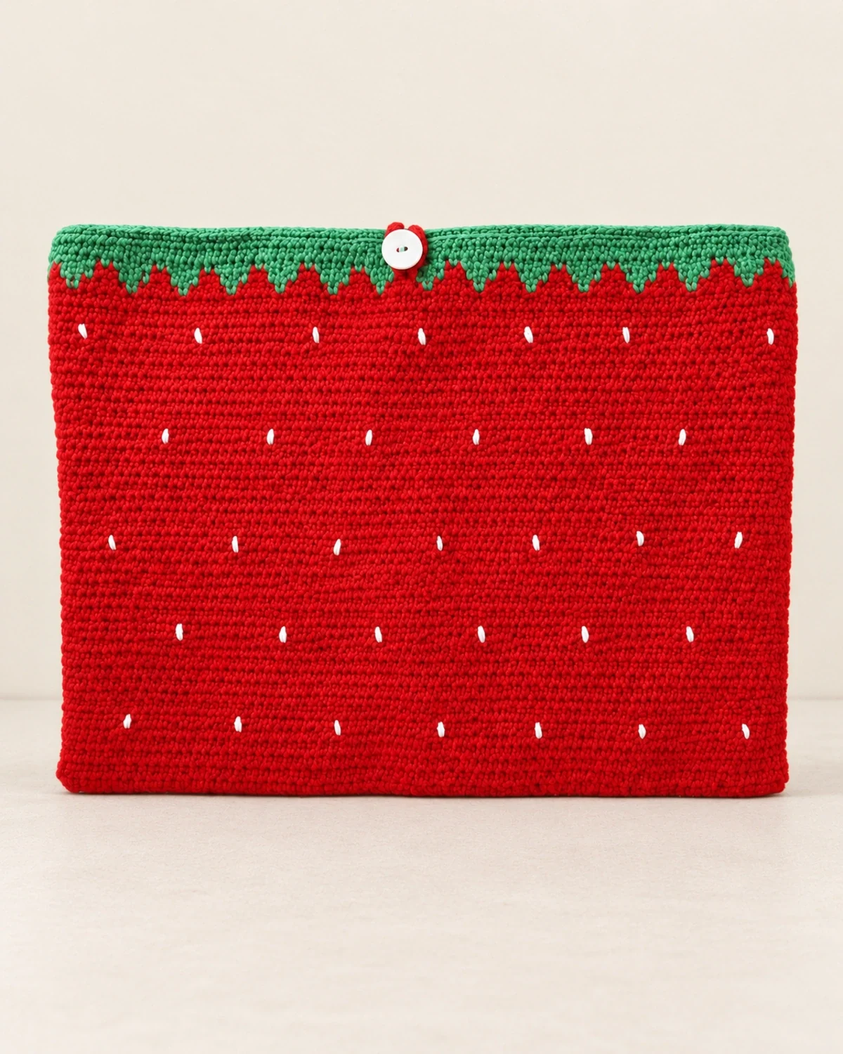 Crocheted laptop sleeve with a strawberry motif.