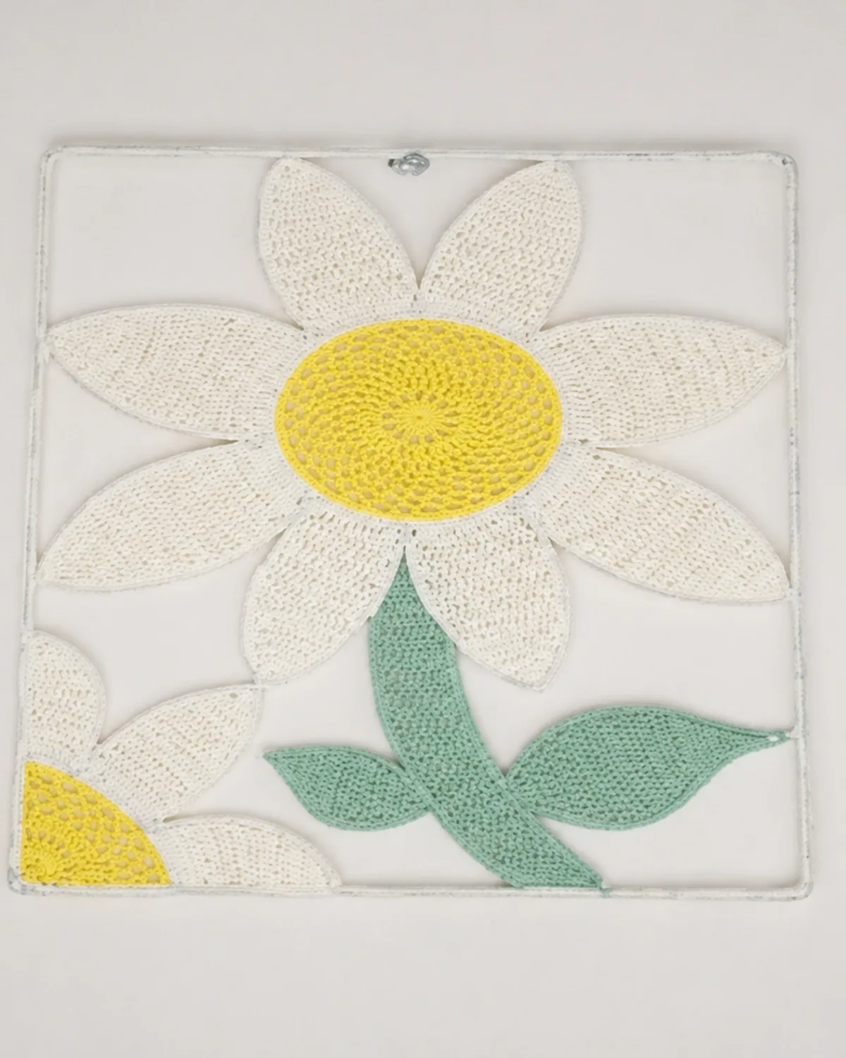 Rectangular floral wall hanging with white petals, yellow centres and green stems.